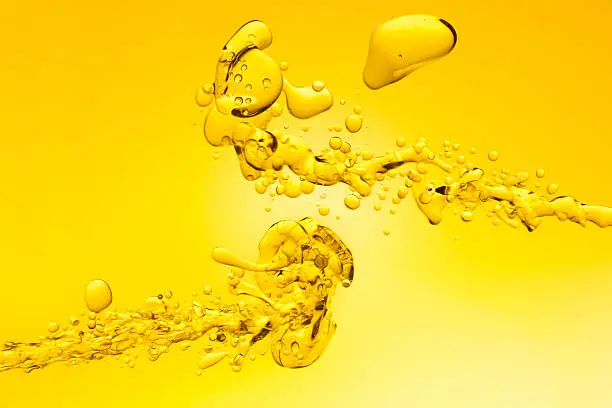 Photo of Yellow oil splashing into water background