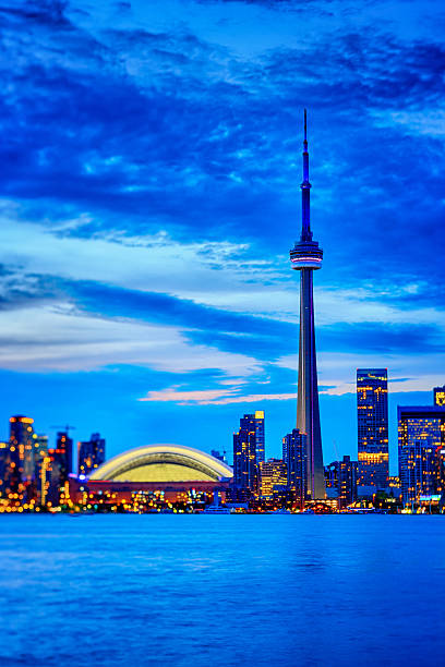 Toronto cityscape with CN Tower and baseball stadium at dusk