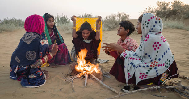 Indian kids setting up bonfire on sand dune