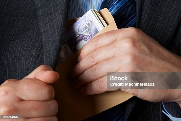 Businessman Putting Envelope Filled With Sterling In Jacket Pocket Stock Photo - Download Image Now