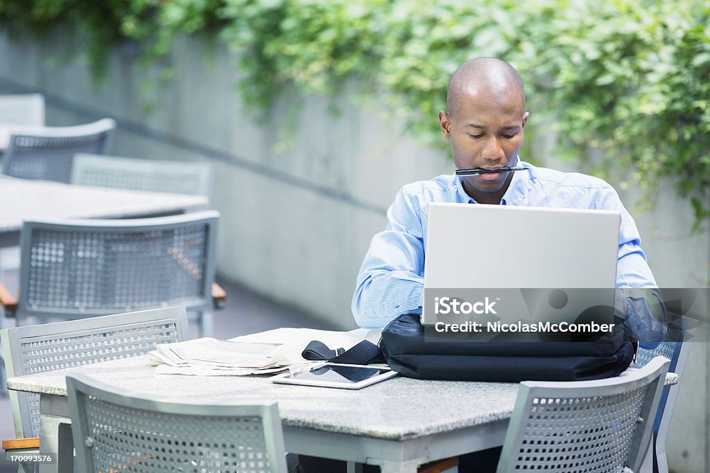 忙しいビジネスマンにノートパソコンの屋外のタイピング - カフェのロイヤリティフリーストックフォト