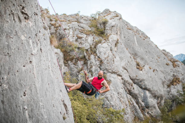 istock A concentrated male climber overcomes extremely steep terrain by climbing a mountain and using a climbing rope 1700935762