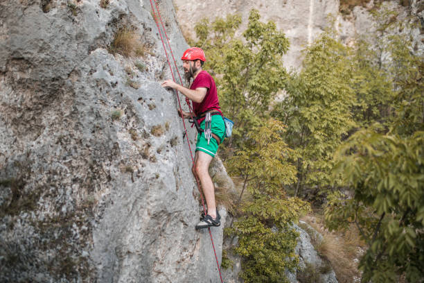 istock A concentrated man with a protective helmet climbs a mountain and enjoys his favorite extreme sport - mountain climbing 1700939018