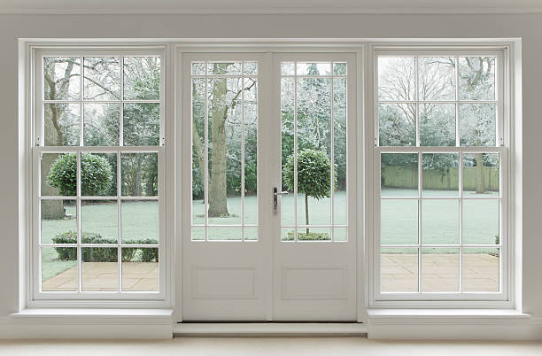 frosty view through white windows Beautifully crafted Georgian white wooden windows and patio doors with a view towards a wintery garden covered in frost.  window latch stock pictures, royalty-free photos & images