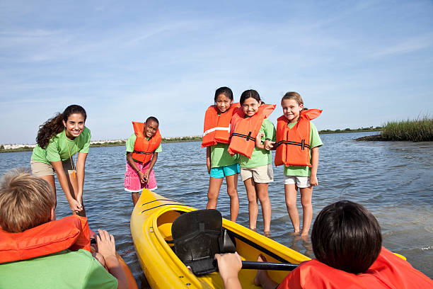 ajudante de colônia de férias de verão e crianças com caiaques - summer camp child teenager kayak - fotografias e filmes do acervo