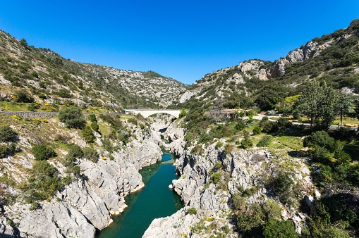 An aerial view of the Devil's Bridge over a narrow gorge of the Herault river in South France