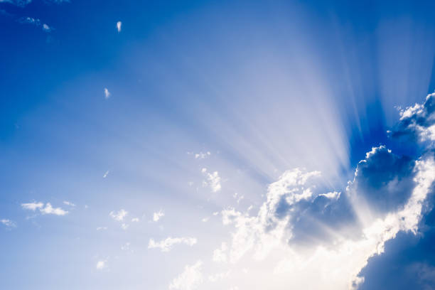 istock Sunbeams rising from a large cloud in intense blue sky on a summer afternoon 1700952758