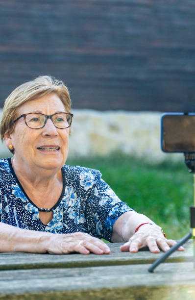 istock Senior woman vlogging in the park 1700957191