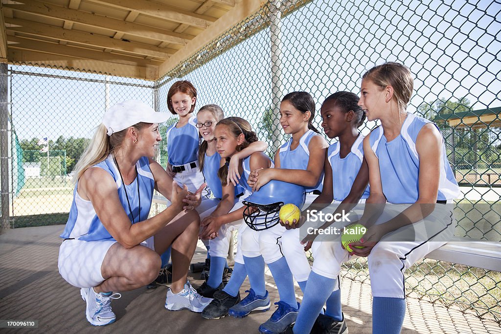Girls softball équipe de banc de touche avec entraîneur - Photo de Enfant libre de droits