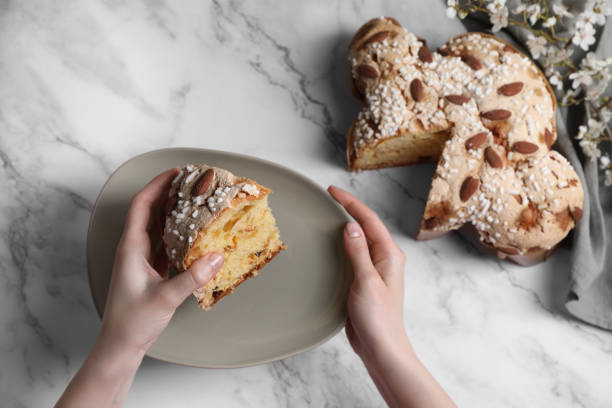 mujer con un pedazo de delicioso pastel de paloma de pascua italiano (tradicional colomba di pasqua) en una mesa de mármol blanco, vista superior - smelling bread bakery women fotografías e imágenes de stock