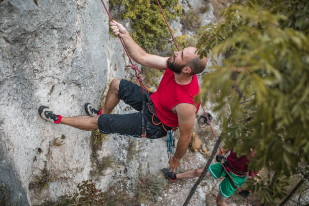 istock Two male climbers climb a mountain during the day 1700981168