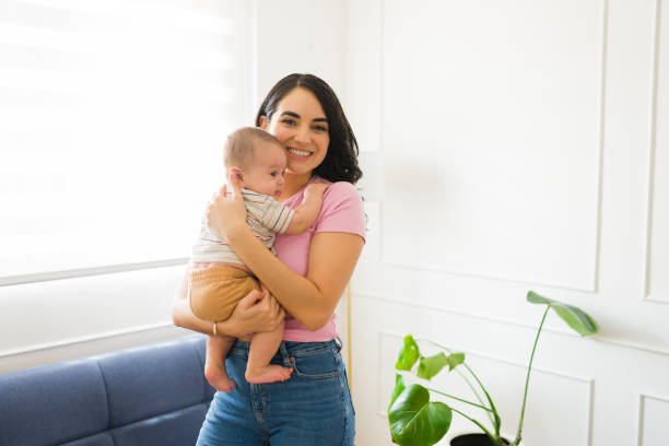 istock Beautiful mom carrying her cute newborn child 1700985392