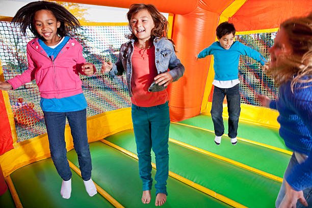 kinder in bounce house - house bouncing multi colored outdoors stock-fotos und bilder