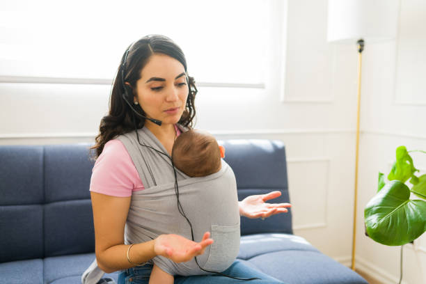 istock Attractive working mom with a baby carrier 1700988668