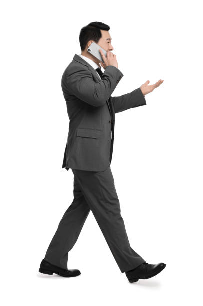 istock Businessman in suit talking on phone against white background 1700991514