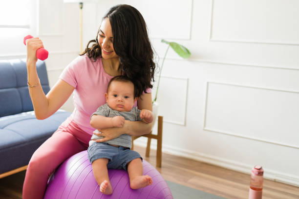 istock Attractive mother with her baby doing a home workout 1700994810