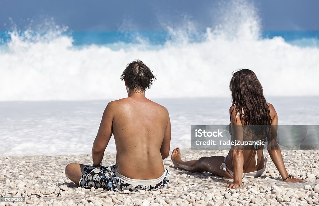 Пара, сидящая на пляже - Стоковые фото Myrtos Beach роялти-фри