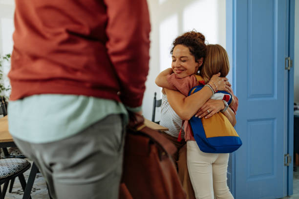 istock Mother hugging daughter while her father waits 1701002402