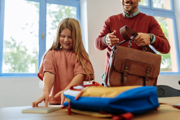istock Father and daughter packing for work and school together 1701002403