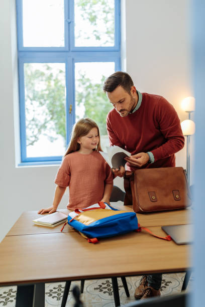 istock Father and daughter checking her school books 1701002408