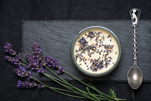 Creme brulee with lavender. The perfect contrast of creamy sweets with crunchy caramel and the aroma of fragrant lavender. On a gray background