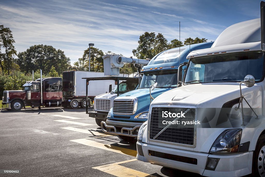 Frentes de camiones en estacionamiento el sol de la media tarde - Foto de stock de Parada de camión libre de derechos