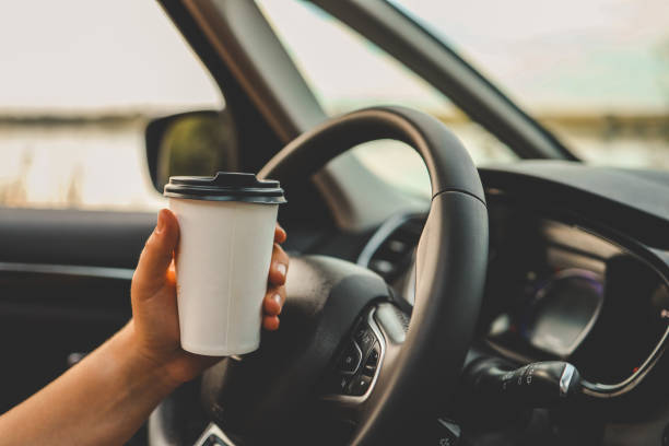 istock Paper cup with coffee in hand, traveling by car 1701004884