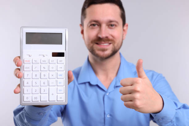 istock Happy accountant with calculator showing thumbs up on light grey background, selective focus 1701006596