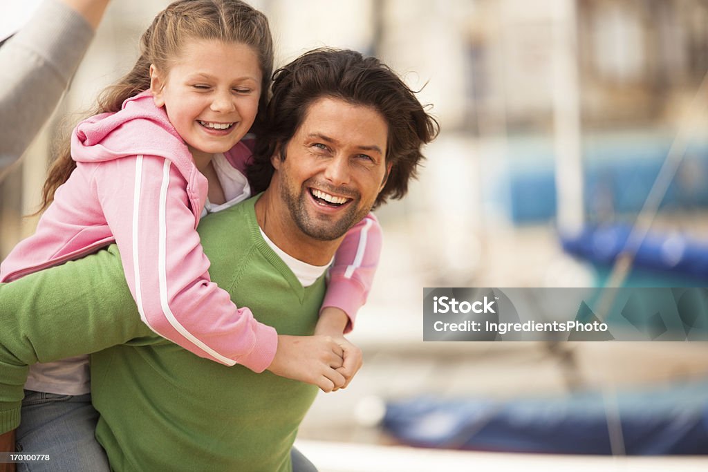 Feliz padre lanzarnos al transporte combinado su sonriendo Monada daugther en la playa - Foto de stock de 30-34 años libre de derechos