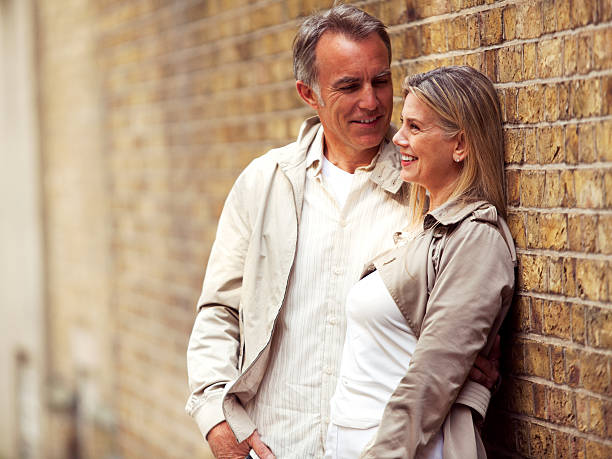 istock Smiling mature couple standing next to the brick wall 170100950