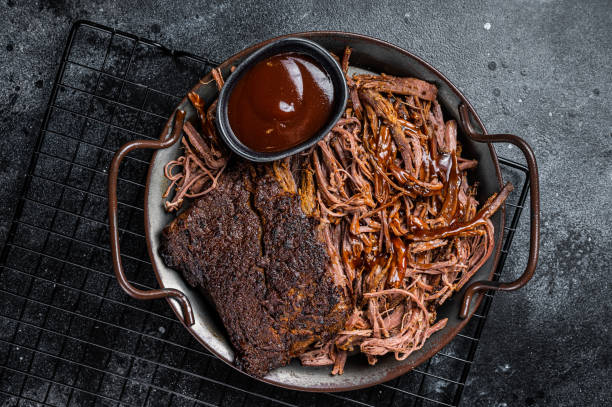 istock Slow Cooked Pulled Beef, Traditional meat rubbed with spices and smoked in a Texas smoker. Black background. Top view 1701012554