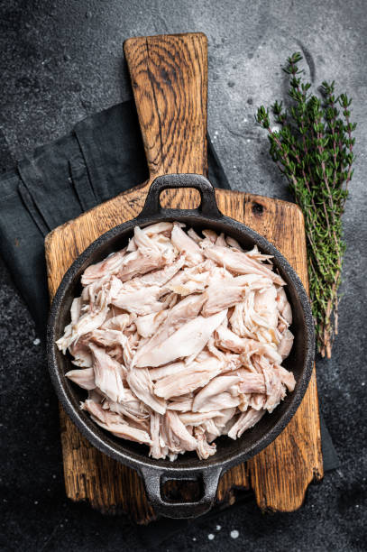 istock Sliced Pieces of chicken meat in a skillet, pulled chicken. Black background. Top view 1701012567