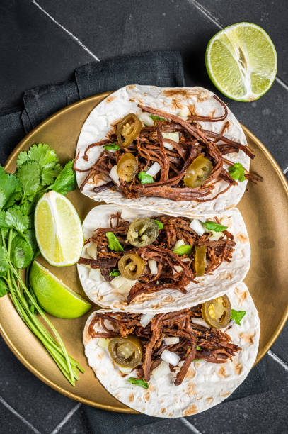 istock Mexican Beef Barbacoa Tacos with Cilantro and Onion. Black background. Top view 1701012573