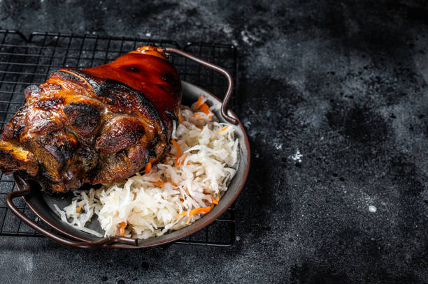 traditional german cuisine roasted pork knuckle schweinshaxe with sauerkraut. black background. top view. copy space - shank sauerkraut german cuisine pork imagens e fotografias de stock