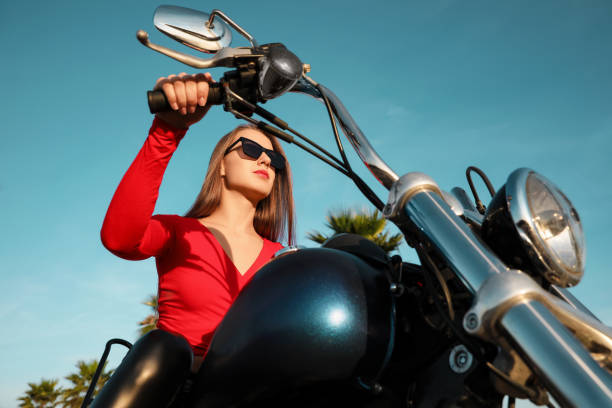 istock Beautiful young woman riding motorcycle on sunny day, low angle view 1701017085
