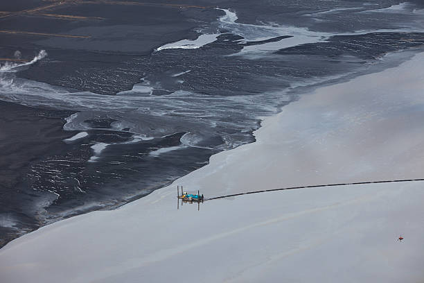 Oilsands Tailings Pond Crude oil seen separated from sand for collection. Tailings ponds are used to separate the heavy oil bitumen from the sticky sand mined from around the area.  Near Fort McMurray, Alberta. oilsands stock pictures, royalty-free photos & images