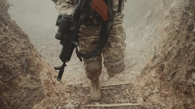 A man in a military uniform with a machine gun