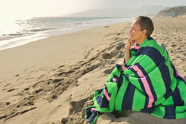 istock Senior Woman Alone on the Beach at Sunset 170102611
