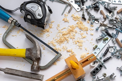 A background with hardware, hand tools and wood shavings isolated in white.