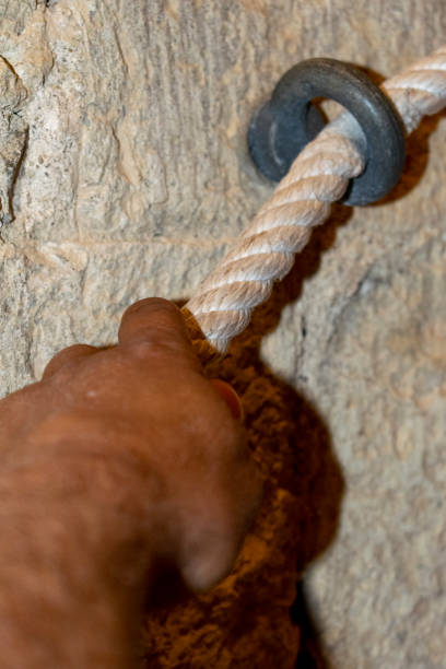 istock Man holds on to a rope to help himself to climb up 1701044620