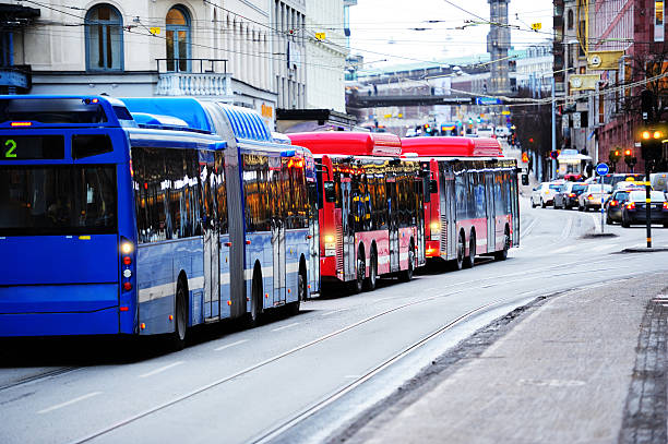 Stockholm, Sweden, August 9, 1986. Two buses on the corner of the Royal Palace, at the intersection of Slottsbacken and Skeppsbron streets, which runs along the Norrström River. In the distance, many cars and boats can be seen on the river, and in the background, the Grand Hotel and the National Museum. The photo was taken from a moving bus.
