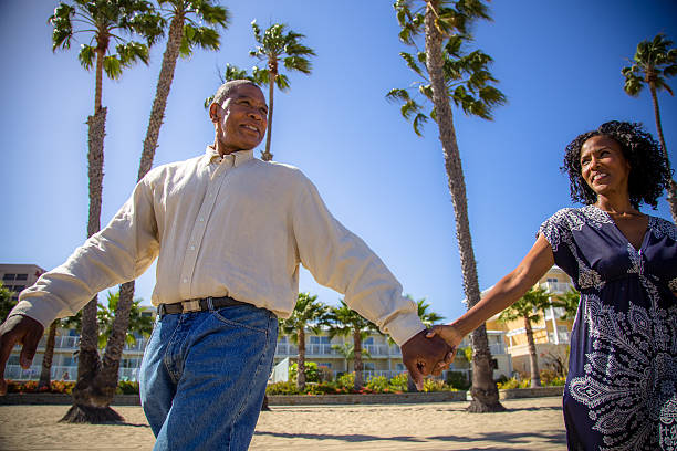 istock Couple holding hands smiling and walking on the beach 170105107