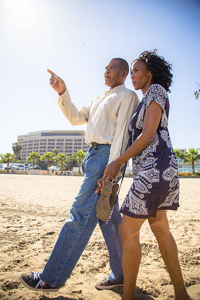 istock Couple holding hands talking and walking on the beach 170105113