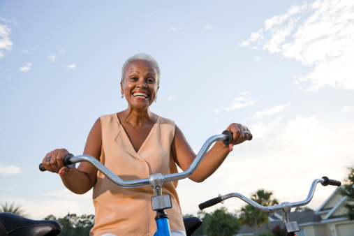 Senior African American woman riding bicycle.
