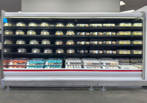Fridge full of cakes and cupcakes in a supermarket retail display