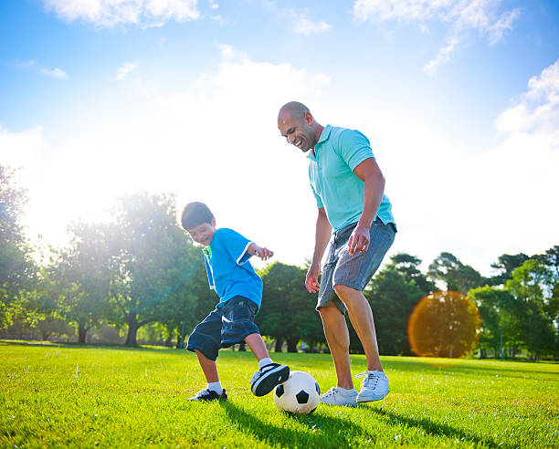 istock Father and son playing football together 170105798