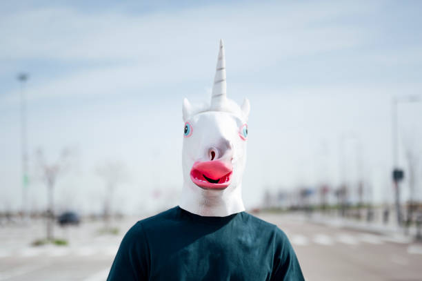istock Man with a unicorn mask outdoors 1701059087