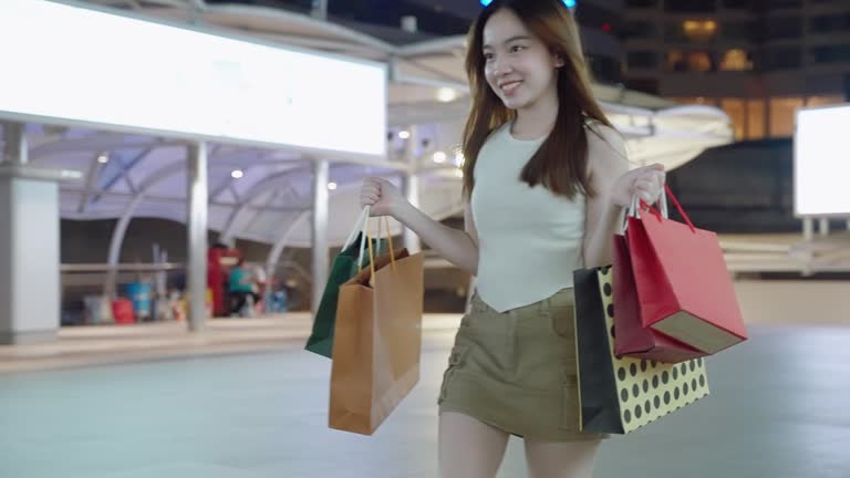 Asian woman carry shopping bags in a shopping mall.