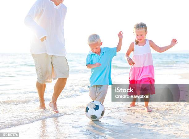 Pai Jogando Futebol Com Seu Crianças - Fotografias de stock e mais imagens de Anoitecer - Anoitecer, Ao Ar Livre, Areia