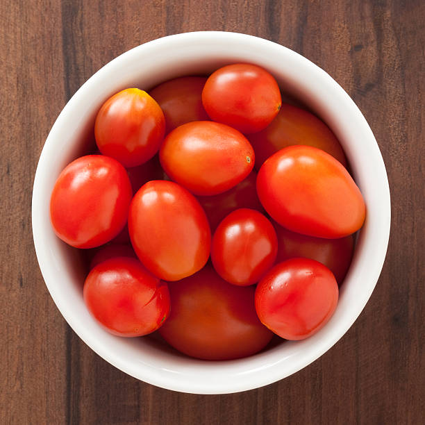 Cherry tomatoes Top view of white bowl full of cherry tomatoes CHERRY TOMATOES stock pictures, royalty-free photos & images